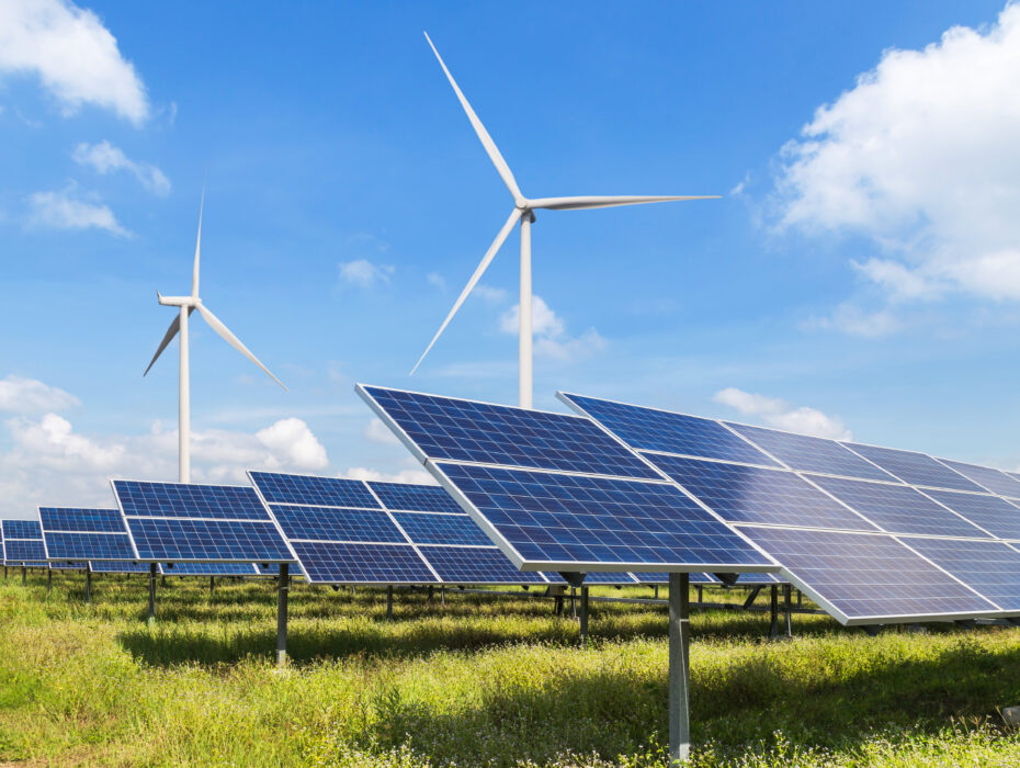 Solar panels and wind turbines under a blue sky.