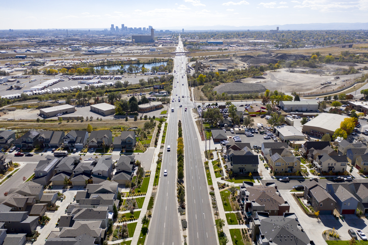Aerial view of Pecos Street extending towards a distant city skyline, with residential neighborhoods and commercial areas on either side.